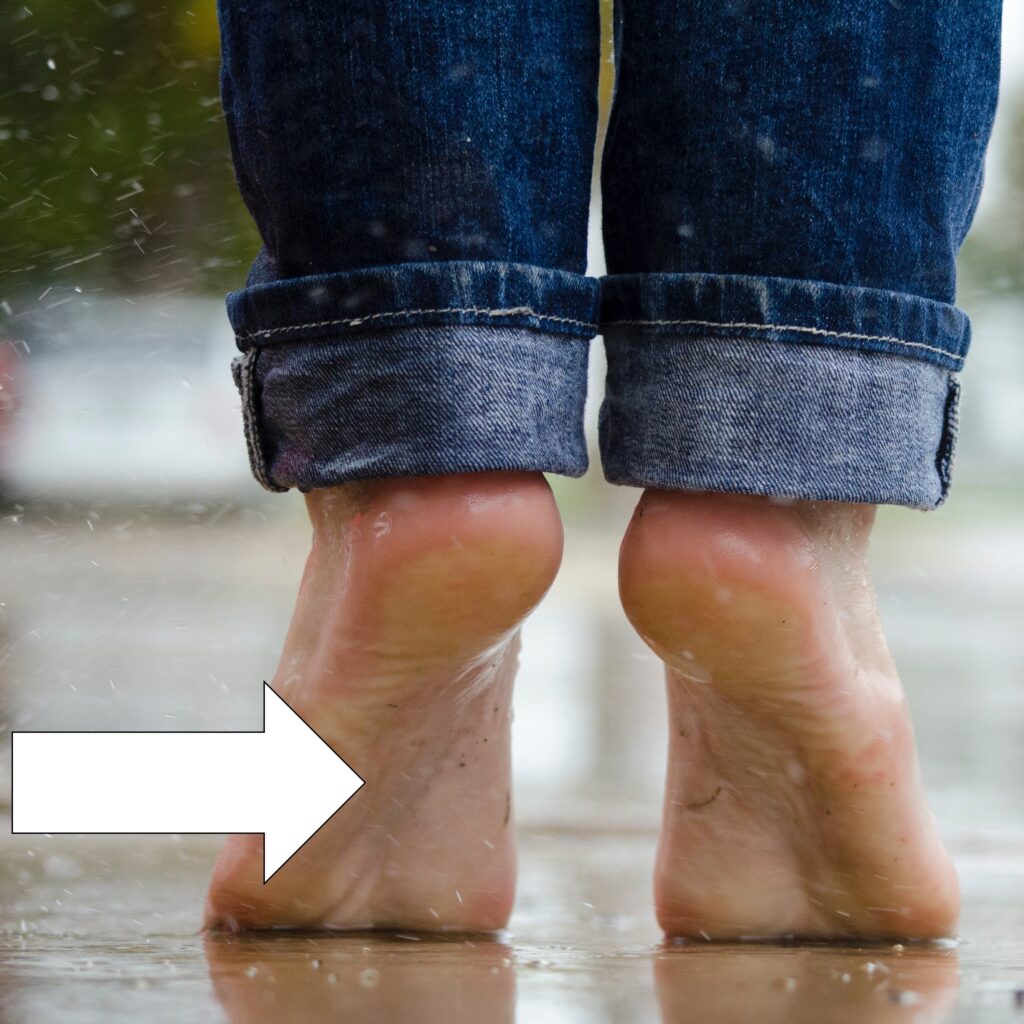 A person is standing on their toes and an arrow is pointing to the sole of one of the feet to illustrate which body vocabulary term to focus on.