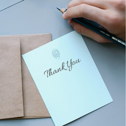 A person is writing a thank you card--an example of good etiquette and manners